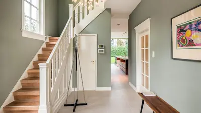 a staircase in a home with a painting on the wall at Villa van Reenenpark in Bergen