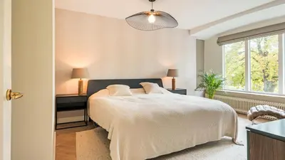 a bedroom with a large bed and a window at Villa van Reenenpark in Bergen