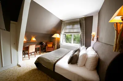 a bedroom with a bed and a desk in a room at Landgoed Duin & Kruidberg in Santpoort-Noord