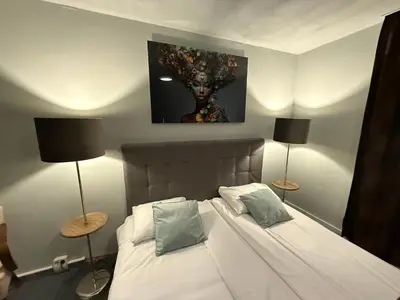 a bedroom with a bed with a painting on the wall at Het Rechthuis in Uithoorn