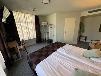 a hotel room with a bed and a window at Het Rechthuis in Uithoorn