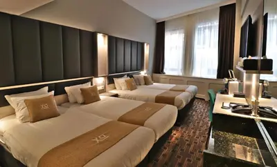 a hotel room with two beds and a television at XO Hotels City Centre in Amsterdam