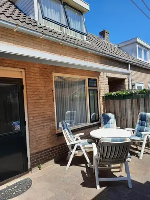 a patio with a table and chairs and a house at Zomerhuis Visser Egmond in Egmond aan Zee