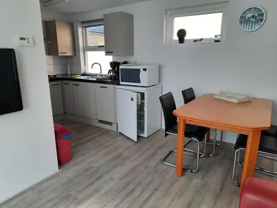 a small kitchen with a table and a table and chairs at Zomerhuis Visser Egmond in Egmond aan Zee