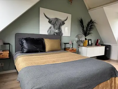 a bedroom with a bed with a picture of a cow at Loft met veel zonlicht in Breukelen