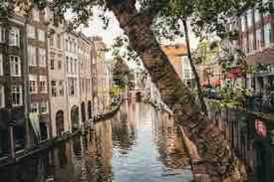 a view of a canal in a city with buildings at Loft met veel zonlicht in Breukelen