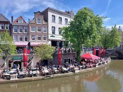 a group of people sitting at tables by a river at Loft met veel zonlicht in Breukelen