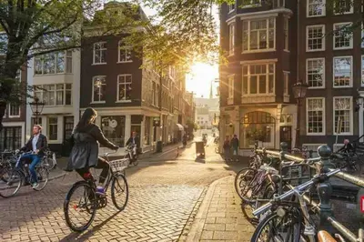 a woman riding a bike down a cobblestone street at Loft met veel zonlicht in Breukelen