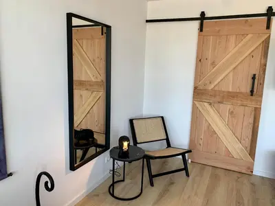 a mirror and a chair in a room with a door at Amsterdam Beach Apartment 76 in Zandvoort
