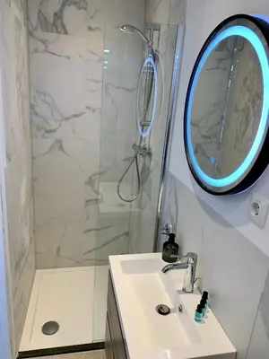 a bathroom with a shower and a sink and a mirror at Amsterdam Beach Apartment 76 in Zandvoort