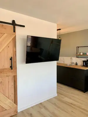 a large flat screen tv on a wall in a kitchen at Amsterdam Beach Apartment 76 in Zandvoort