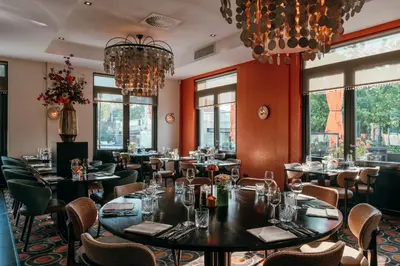 a restaurant with tables and chairs and windows at Van der Valk Hotel Leiden in Leiden