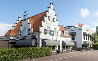 a white building with a red roof at Van der Valk Hotel Leiden in Leiden