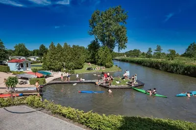 a group of people swimming in a river at Cozy chalet near Amsterdam at Camping Venhop in Berkhout