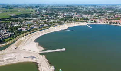 an aerial view of a beach and a body of water at Cozy chalet near Amsterdam at Camping Venhop in Berkhout