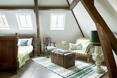 a bedroom with a bed and a chair and a table at Landgoed Huis te Jaarsveld in Jaarsveld