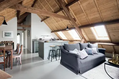 a living room with a couch and a kitchen at Landgoed Huis te Jaarsveld in Jaarsveld