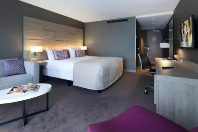 a hotel room with a bed and a couch and a table at Van der Valk Hotel Haarlem in Haarlem