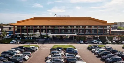 a building with a lot of cars parked in a parking lot at Van der Valk Hotel Breukelen in Breukelen