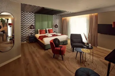 a hotel room with a bed and a living room at Van der Valk Hotel Breukelen in Breukelen