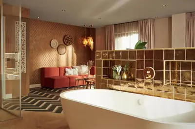 a bathroom with a tub and a living room at Van der Valk Hotel Breukelen in Breukelen
