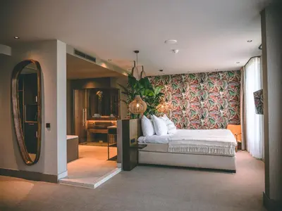 a bedroom with a bed and a large mirror at Van der Valk Hotel Breukelen in Breukelen