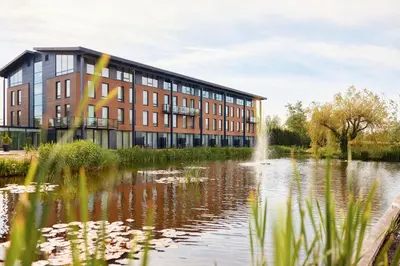 a building with a pond in front of it at Van der Valk Hotel Breukelen in Breukelen