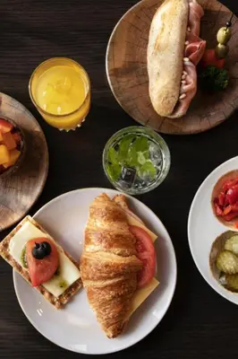 a table with plates of food on a table at Quentin Arrive Hotel in Amsterdam