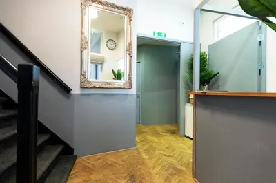 a mirror on a wall next to a staircase at Quentin Arrive Hotel in Amsterdam