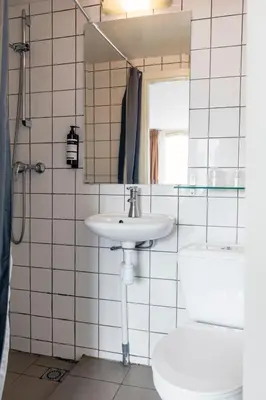 a bathroom with a sink and a toilet and a mirror at Quentin Arrive Hotel in Amsterdam