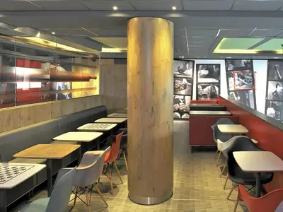 a restaurant with tables and chairs and a pole at ibis Amsterdam City West in Amsterdam