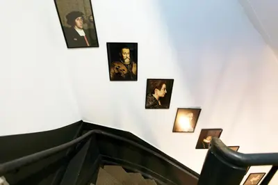 a group of pictures on a wall above an escalator at Quentin Canal House Hotel in Amsterdam