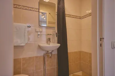 a bathroom with a sink and a shower at Quentin Canal House Hotel in Amsterdam