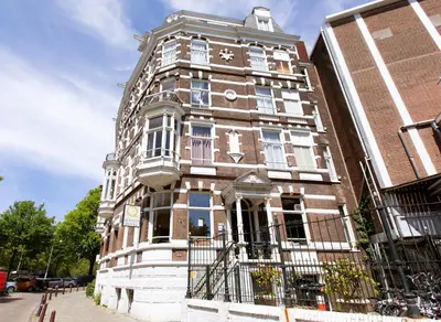 a tall brick building with a clock on it at Quentin Canal House Hotel in Amsterdam