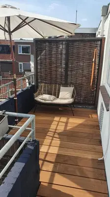 a balcony with a hammock and an umbrella at Luminous appartment - Juliana Park free parking in Utrecht