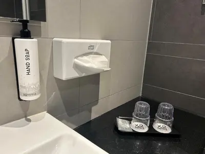 a bathroom with a sink and a soap dispenser at XO Hotels Couture in Amsterdam
