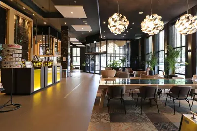 a lobby of a store with tables and chairs at XO Hotels Couture in Amsterdam
