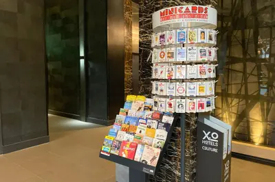 a stack of magazines on a pole in a lobby at XO Hotels Couture in Amsterdam