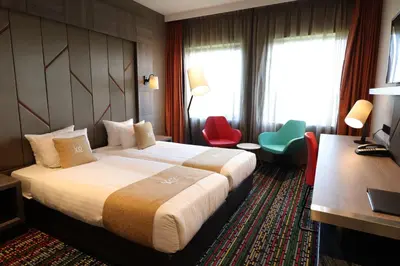 a hotel room with a bed and a desk and chairs at XO Hotels Couture in Amsterdam