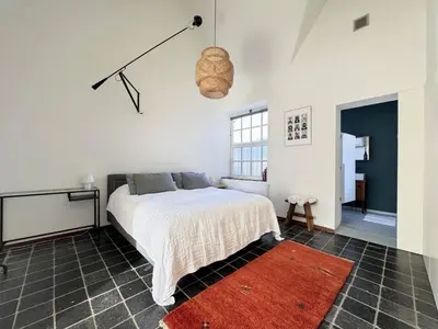 a bedroom with a bed and a red rug at Apartment in former Bathhouse in Amsterdam