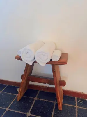three towels are sitting on a wooden stool at Apartment in former Bathhouse in Amsterdam