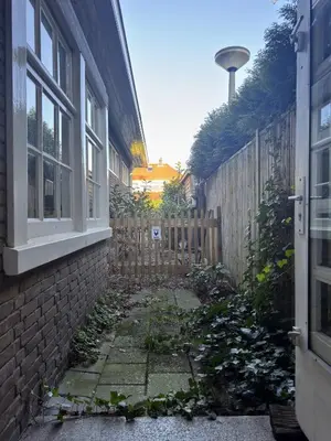 an alley between a house and a fence at Apartment in former Bathhouse in Amsterdam