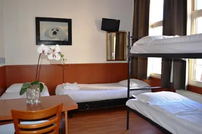 a dorm room with two bunk beds and a table at Hotel Continental Amsterdam in Amsterdam