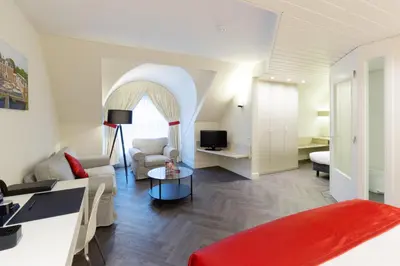 a living room with a couch and a table at Fletcher Hotel-Restaurant Oud London in Zeist