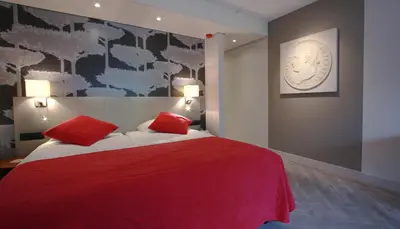 a bedroom with a red bed with two red pillows at Fletcher Hotel-Restaurant Oud London in Zeist