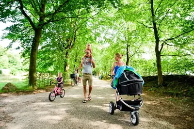 a woman and a woman walking with a child and a stroller at Fletcher Hotel-Restaurant Oud London in Zeist