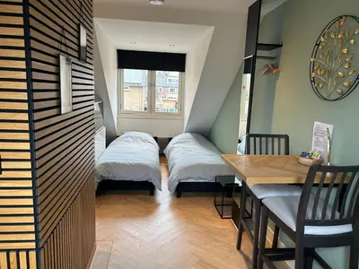 a small room with two beds and a table at Bnb de leeuw in Badhoevedorp
