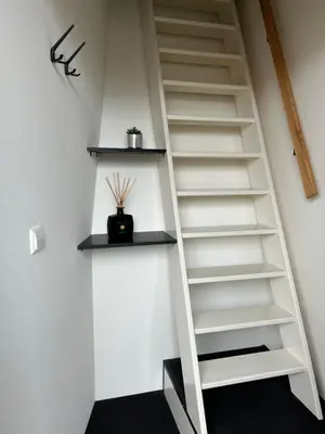 a staircase with white shelves in a room at Bnb de leeuw in Badhoevedorp