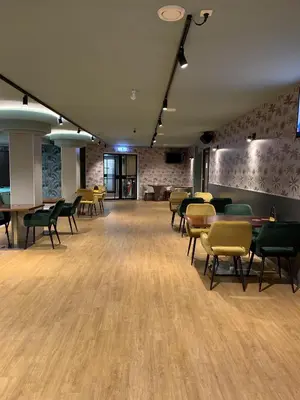 a large room with chairs and tables and a brick wall at Hotel The Globe in Amsterdam