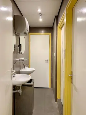 a bathroom with two sinks and a white door at Hotel The Globe in Amsterdam